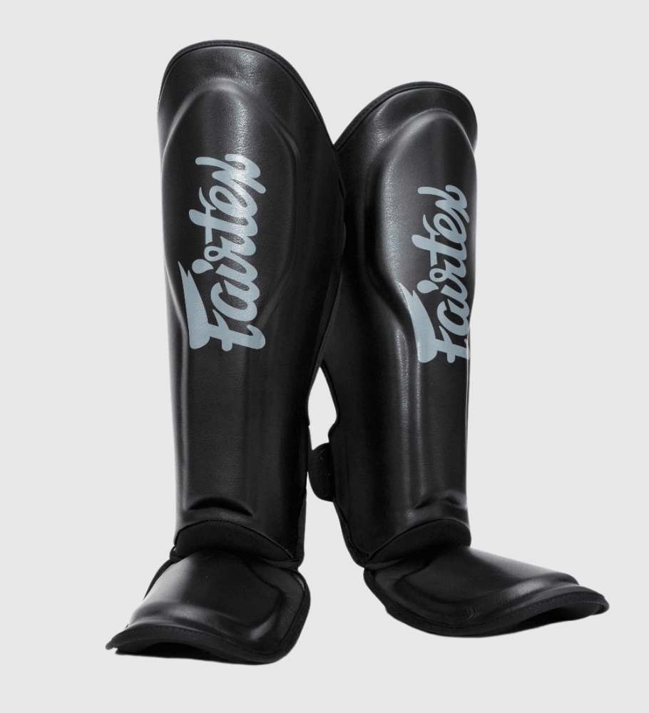 Fairtex Kickboks Scheenbeschermers FXB in zwart met grijze opdruk, gemaakt van kunstleer met klittenbandsluiting